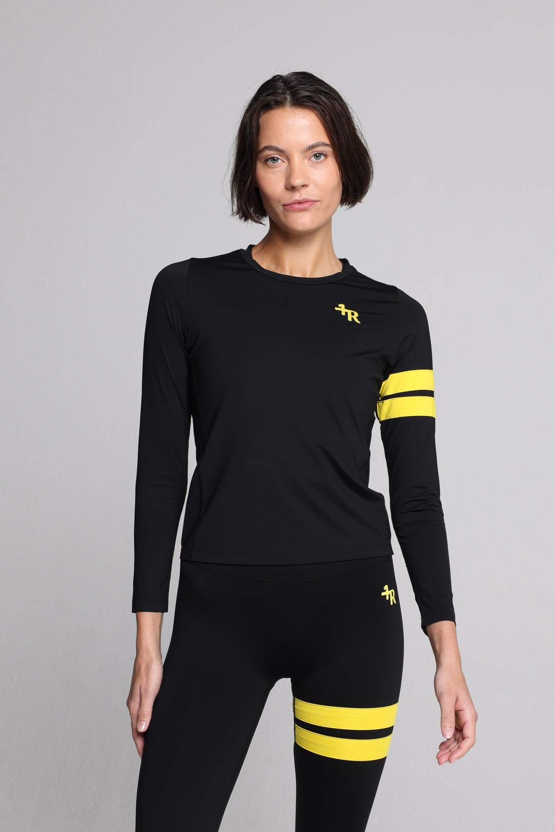 women in black long sleeve performance top and black leggings with yellow stripes top premium luxury activewear by One More Reason high-performance fitness apparel
