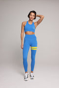woman wearing blue high-waisted leggings and tank top with yellow stripes by One More Reason.