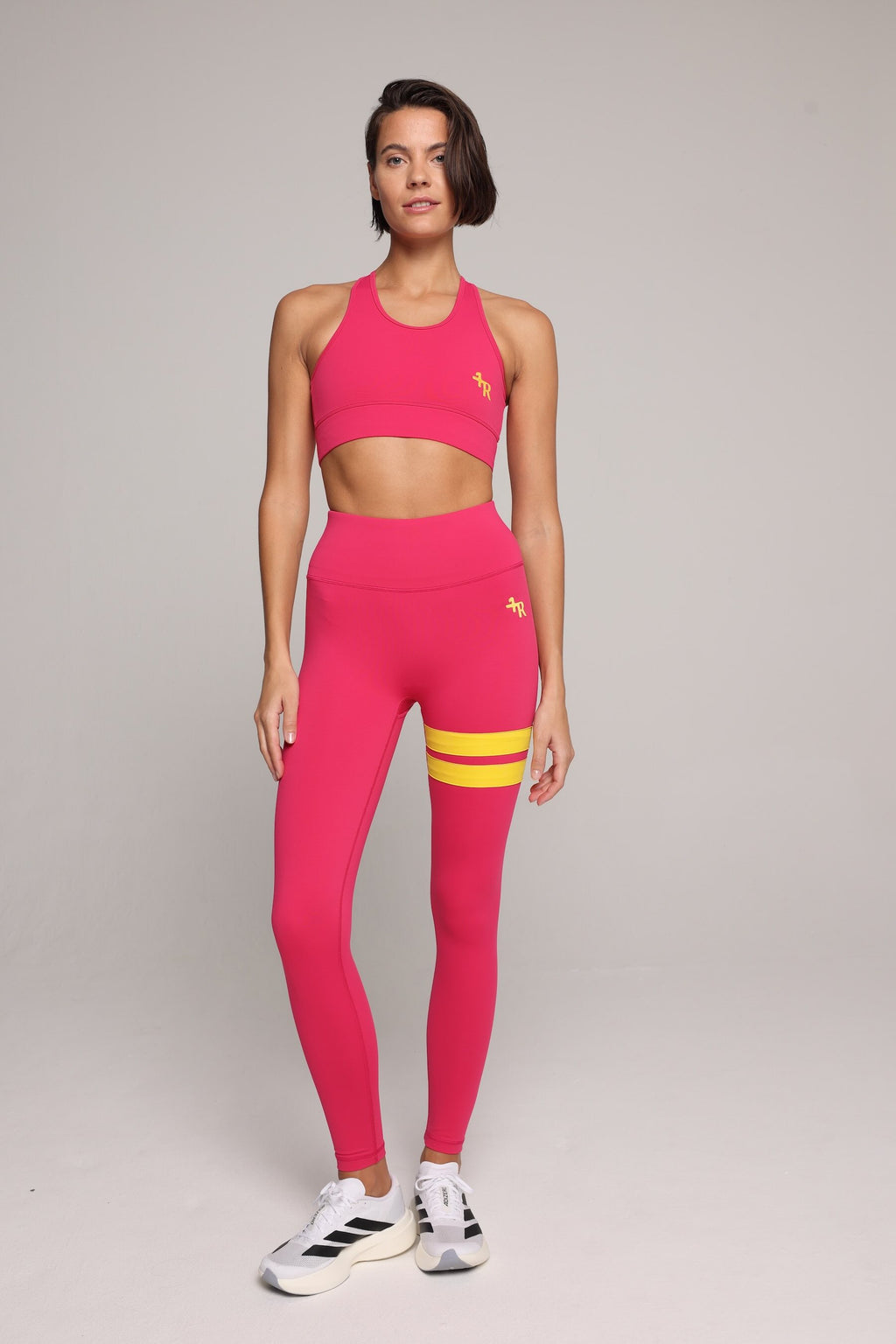 woman wearing pink performance tank top and pink performance leggings with yellow stripes by One More Reason, top premium women's activewear indoor set