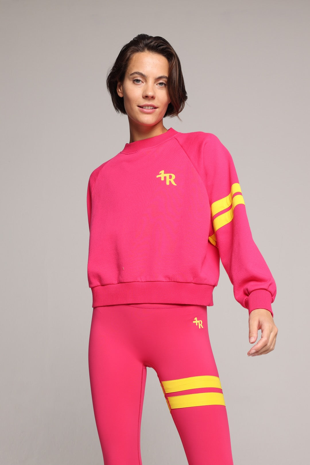 woman wearing premium pink organic crew sweater and pink performance leggings with yellow stripes by One More Reason, women's luxury activewear indoor set