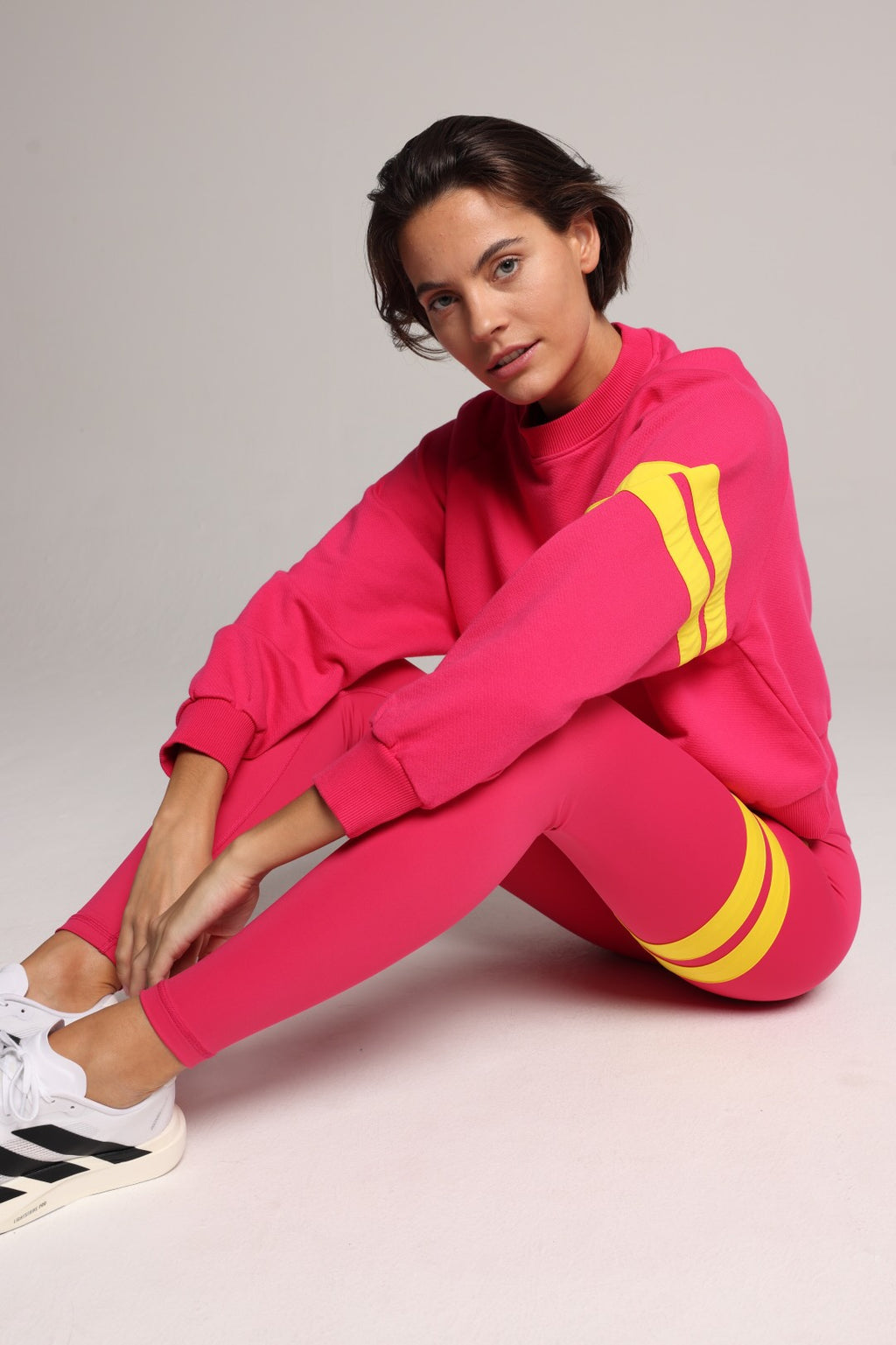 woman wearing premium pink organic crew sweater and pink performance leggings with yellow stripes by One More Reason, women's luxury activewear indoor set