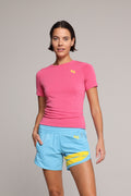 Woman in premium pink t-shirt and blue performance shorts with yellow stripe by one more reason studio set