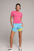 Woman wearing a rose-shirt and powder blue shorts with yellow accents by one more reason studio set