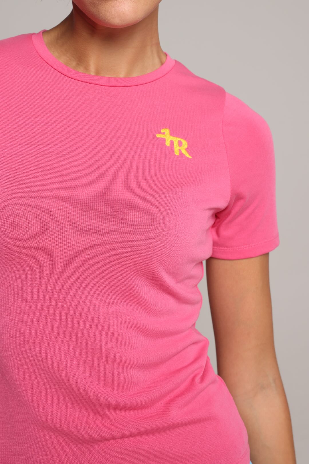 woman wearing a pink t-shirt with a yellow logo by one more reason