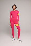 A woman wearing a bright pink performance sleeve and leggings with yellow stripes by One More Reason, the premium sportswear brand made in Europe in a studio setting 