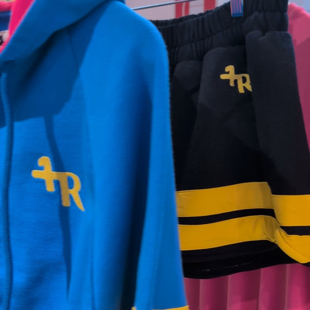Detail view on One More Reason Blue Hoodie and black shorts with yellow stripes