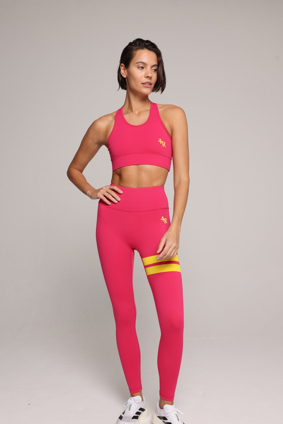 woman wearing premium pink tank top and pink leggings with yellow stripes by One More Reason, women's luxury activewear indoor set