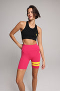Women wearing black performance tank top and pink shorts with yellow stripes by One More Reason, women's activewear studio set.