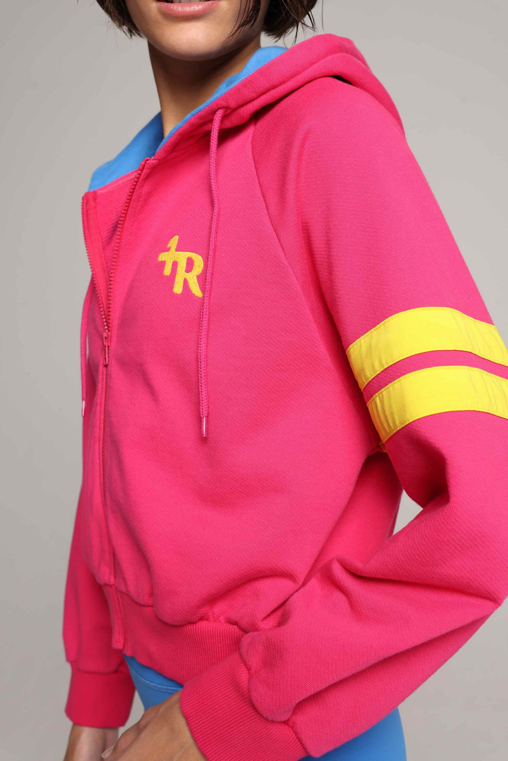 woman wearing bicolor organic cotton zip hoodie in pink and blue and blue tights  with yellow stripes by One More Reason, women's luxury activewear indoor set