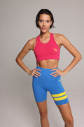 woman wearing pink performance tank top and blue performance shorts with yellow stripes by One More Reason, top premium women's activewear indoor set