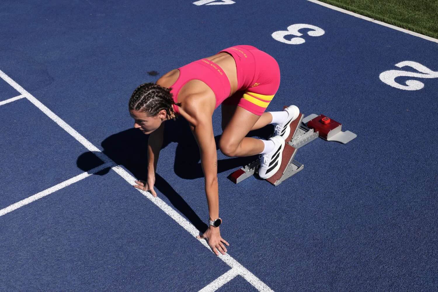 woman wearing pink performance tank top and pink performance shorts with yellow stripes by One More Reason, top premium women's activewear outdoor set