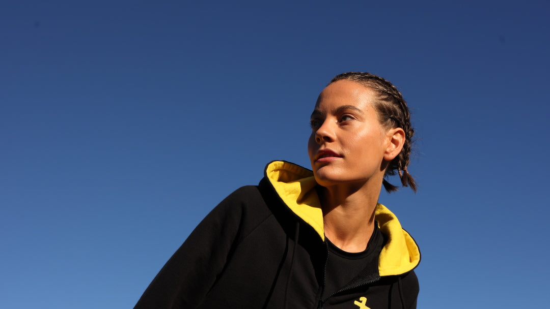 woman wearing premium bicolor hoodie in black and yellow from one more reason crafted in Europe outdoor set