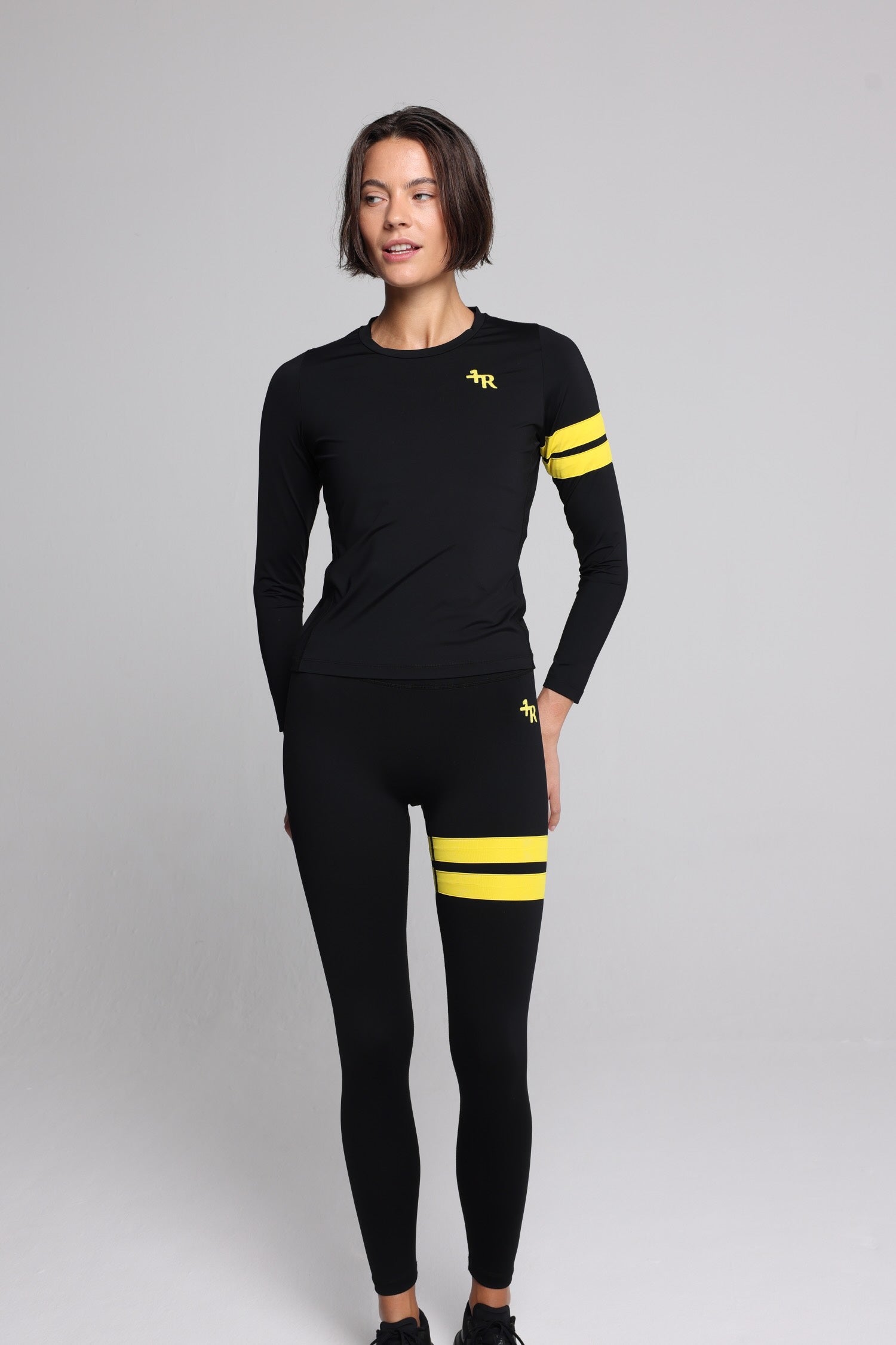 women in black long sleeve performance top and black leggings with yellow stripes top premium luxury activewear by One More Reason high-performance fitness apparel