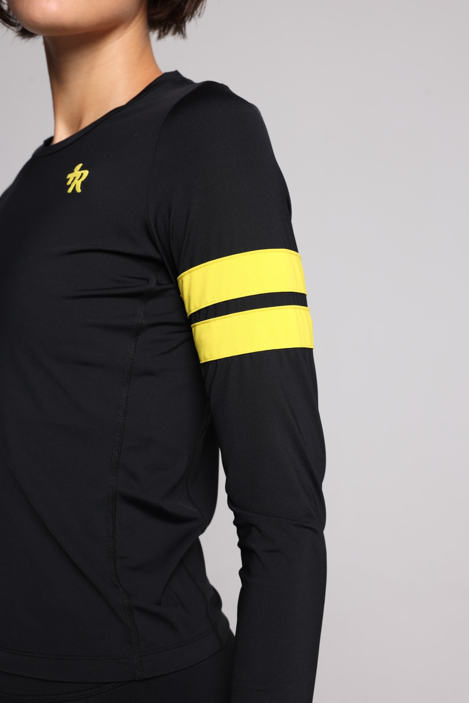 women in black long sleeve performance top with yellow stripes top premium luxury activewear by One More Reason high-performance fitness apparel