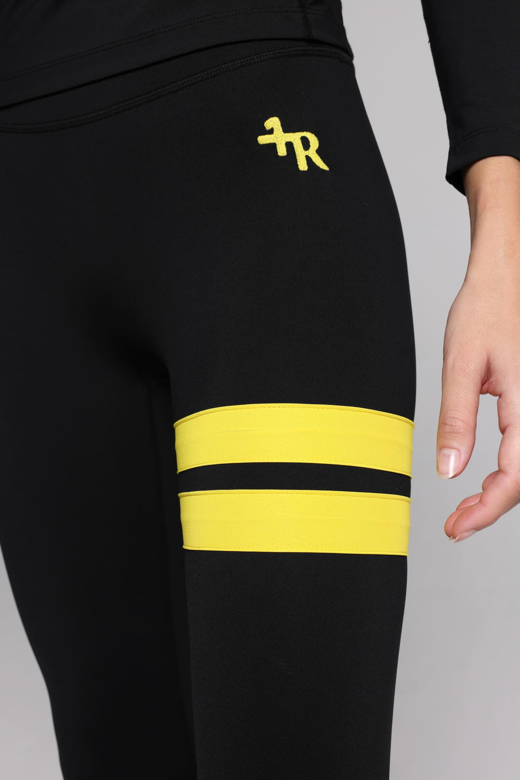 women in black leggings with yellow stripes top premium luxury activewear by One More Reason high-performance fitness apparel