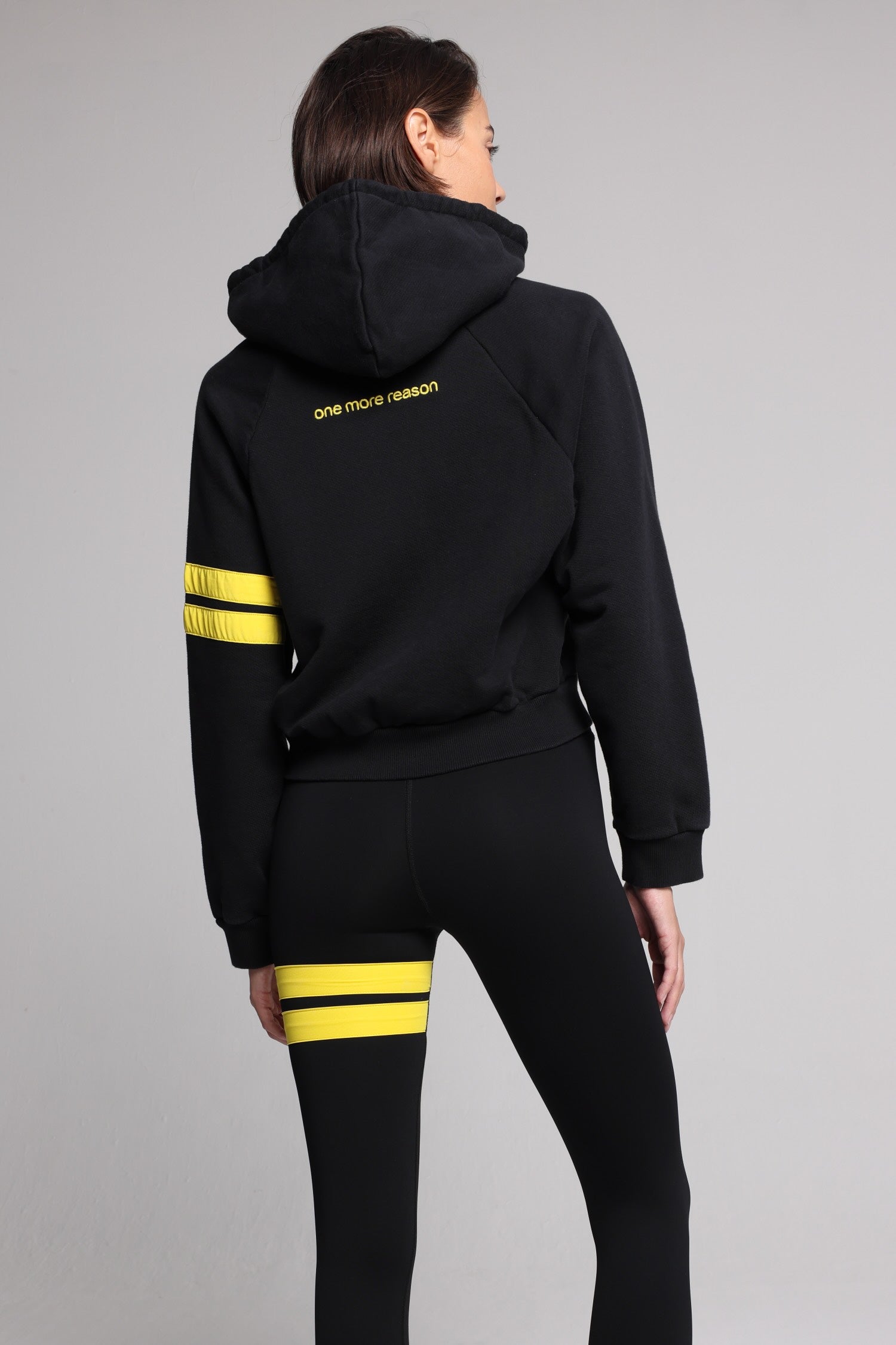 women in bicolor black performance jacket zip hoodie  with yellow stripes top premium luxury activewear by One More Reason high-performance fitness apparel back view