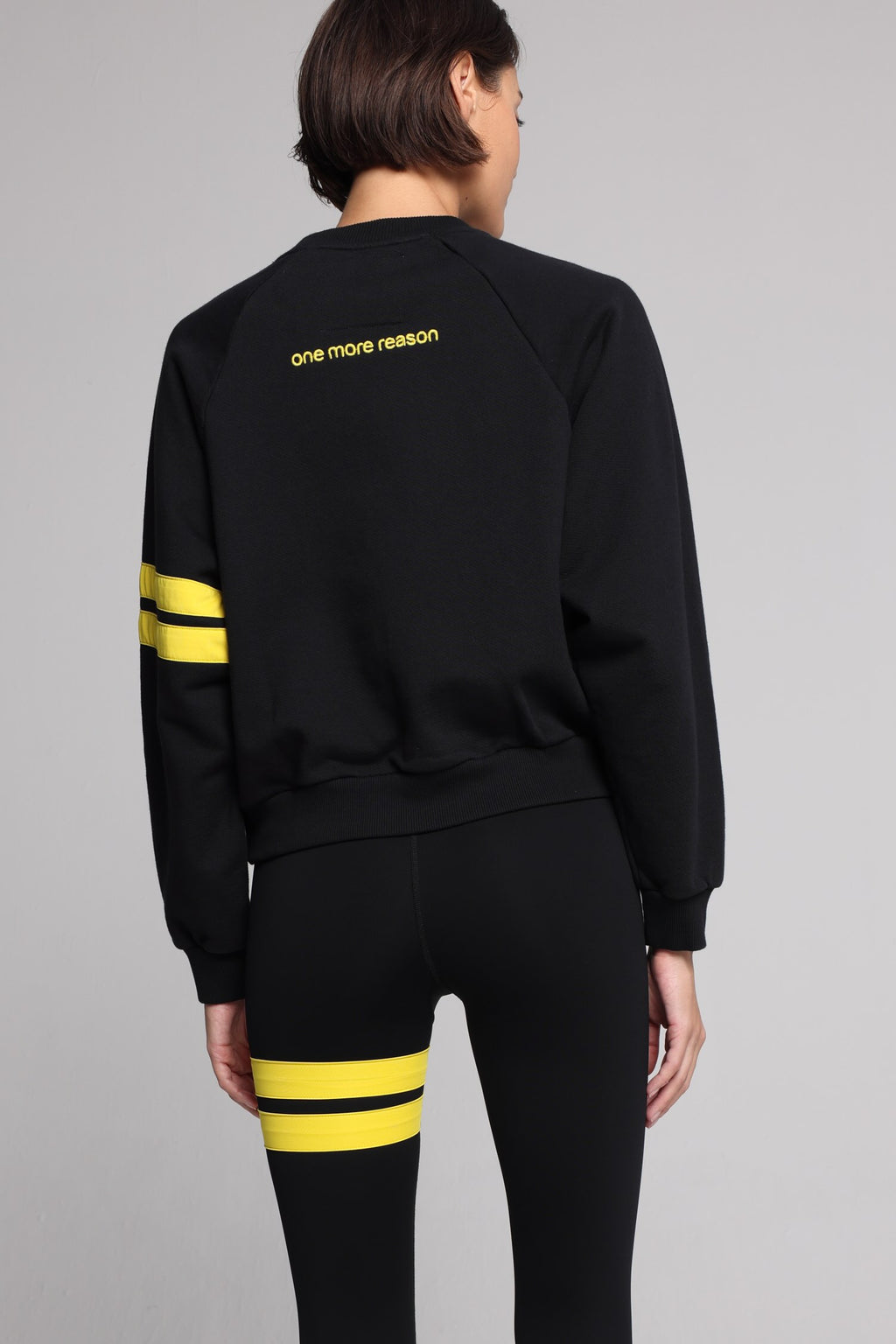 women in black cotton crew sweater  and black leggings with yellow stripes top premium luxury activewear by One More Reason high-performance fitness apparel