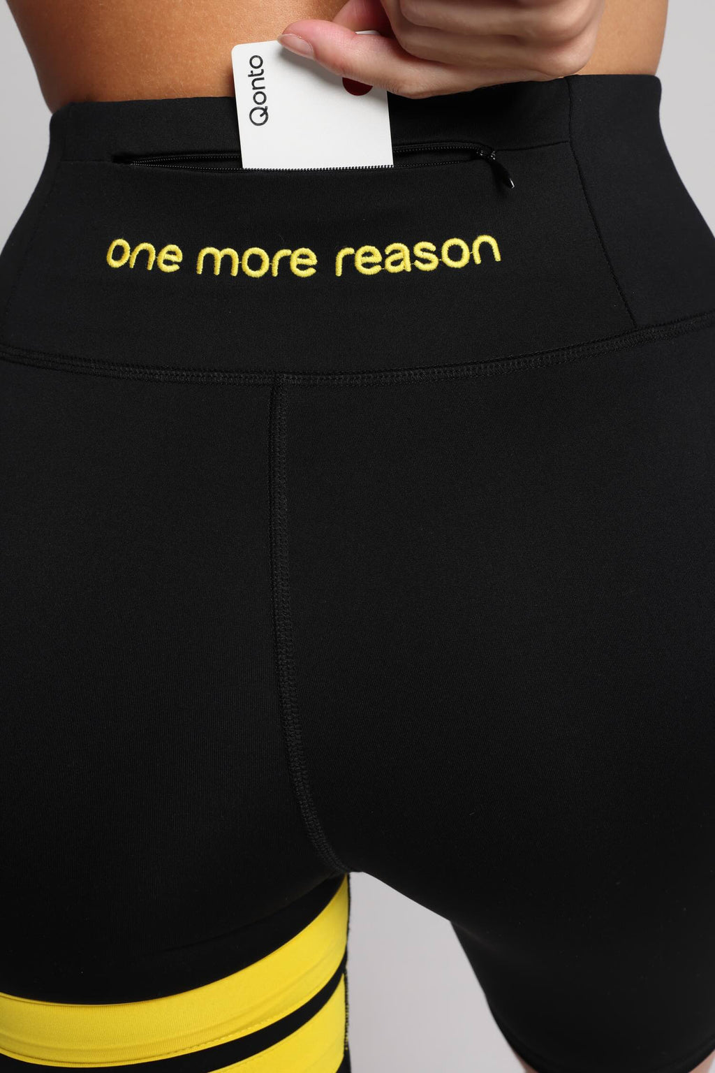 woman in  black tights with yellow stripes top premium luxury activewear by One More Reason high-performance fitness apparel back view