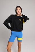 woman in black cotton crew sweater  and blue tights with yellow stripes top premium luxury activewear by One More Reason high-performance fitness apparel