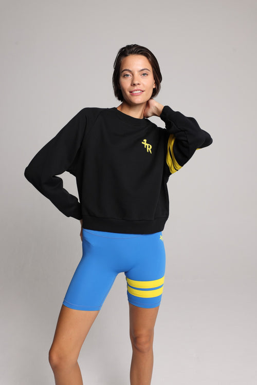 woman in black cotton crew sweater  and blue tights with yellow stripes top premium luxury activewear by One More Reason high-performance fitness apparel