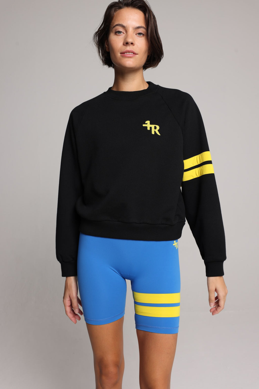 women in black cotton crew sweater  and blue tights with yellow stripes top premium luxury activewear by One More Reason high-performance fitness apparel