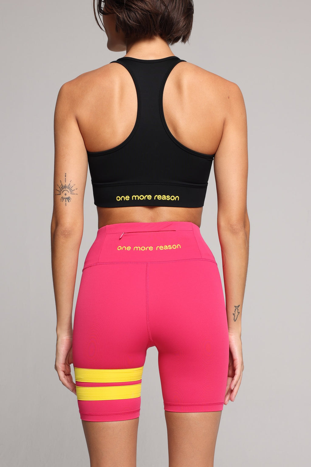 Women wearing black performance tank top and pink performance shorts with yellow stripes by One More Reason, women's activewear indoor set.
