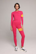 woman wearing pink long sleeve performance top and pink leggings with yellow stripes by One More Reason, women's luxury activewear indoor set
