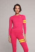 Woman wearing premium pink long sleeve top and pink performance leggings with yellow stripes by One More Reason luxury women's activewear indoor set