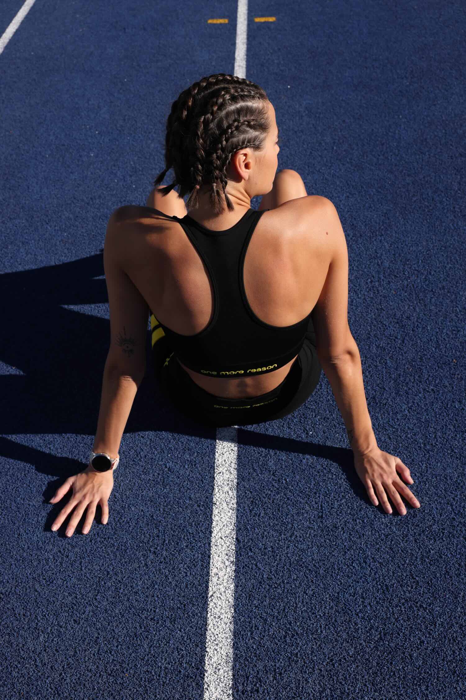 women in black sport tank  and black leggings with yellow stripes top premium luxury activewear by One More Reason high-performance fitness apparel, female athlete outdoor training back view